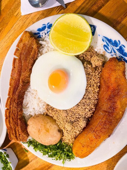 A plate with fried egg, rice, sausage, and a slice of lime. 4