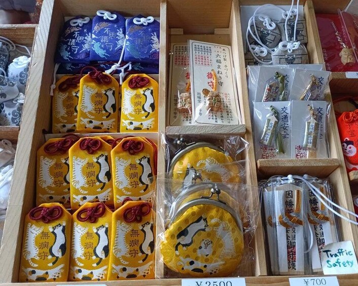 A display of various Japanese souvenirs including keychains, bags, and other items, with price tags visible. 4