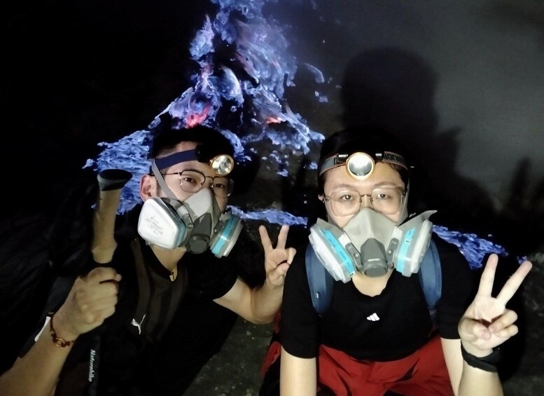 Two people wearing gas masks and holding a glowing object. 1