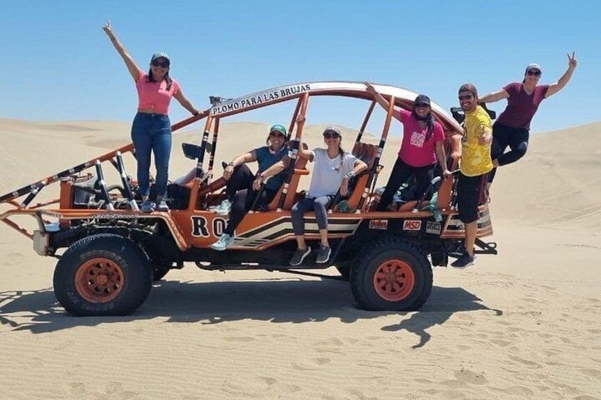 Ein Geländewagen mit Personen in einer Wüste. 4