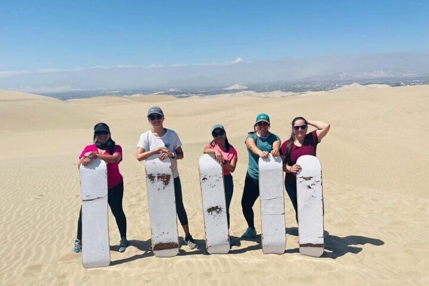 En grupp människor som står i en öken med sanddyner i bakgrunden. 3