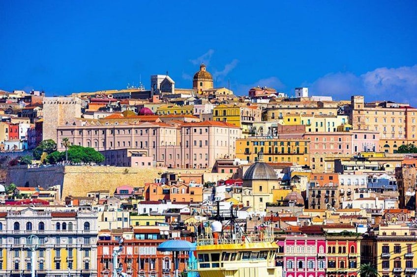 A densely packed cityscape with historic buildings, a prominent dome, and a fortified wall. 1