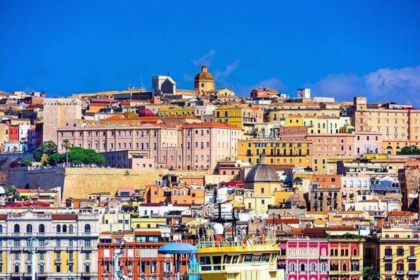 A densely packed urban landscape with historic buildings, a prominent dome structure, and a fortified wall. 1