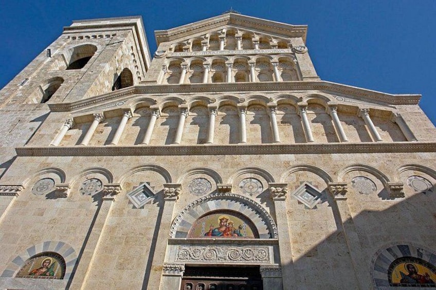 A large stone building with a bell tower, arched windows, and detailed carvings. 2