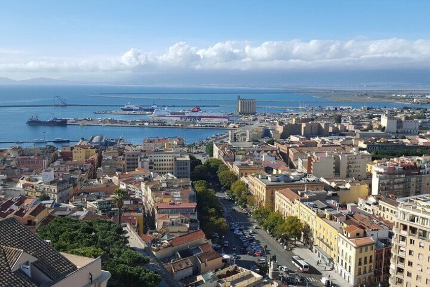 A coastal cityscape with a harbor, buildings, and a clear sky. 2