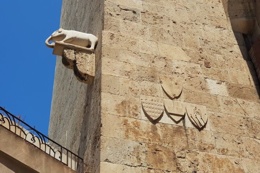 A stone wall with a relief sculpture of a lion and three shields. 3