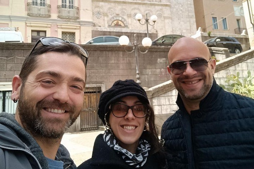 Three people standing in front of a building with a stone facade and a staircase. 5