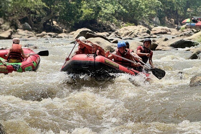 People rafting on a river with rocks and trees in the background. 3