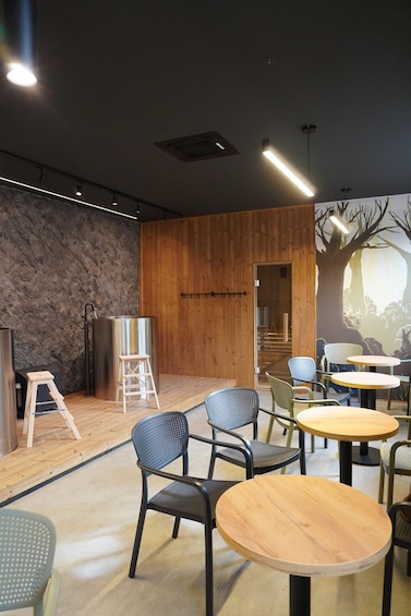 A modern interior with wooden walls, metal furniture, and a mural of a tree. 1