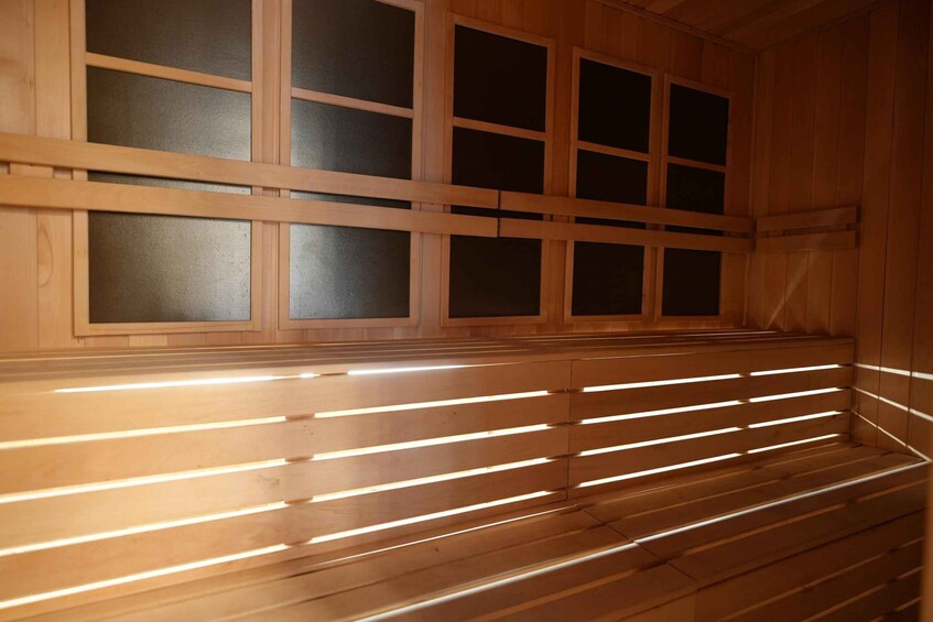 A wooden sauna with slatted benches and frosted glass windows. 2
