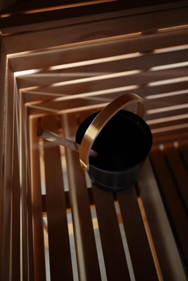 A black pot with a metallic handle on a wooden surface with slats. 5