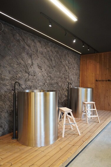 Stainless steel tanks, wooden stools, and a textured wall. 3
