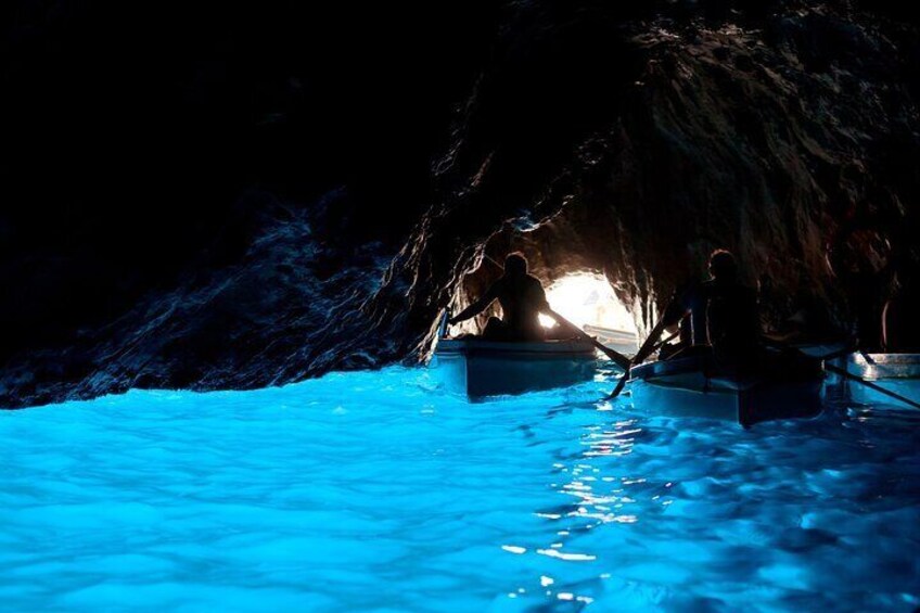People in a cave with a pool of water. 1