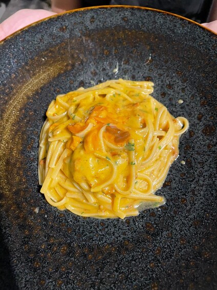 A bowl of pasta with a creamy sauce and onions. 5