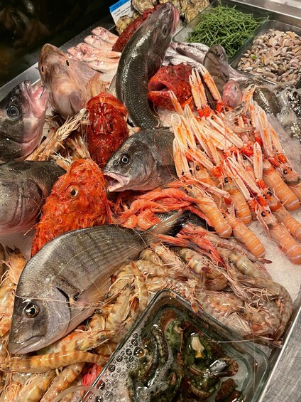 A variety of seafood including fish, shrimp, and mussels displayed on ice. 4