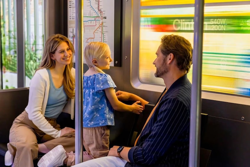 L'intérieur d'un train avec des passagers assis, une carte accrochée au mur et une vue sur l'extérieur du train. 2