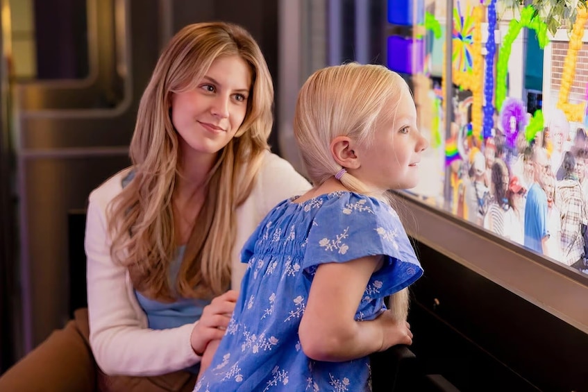 Une femme et un enfant regardent une exposition colorée. 4