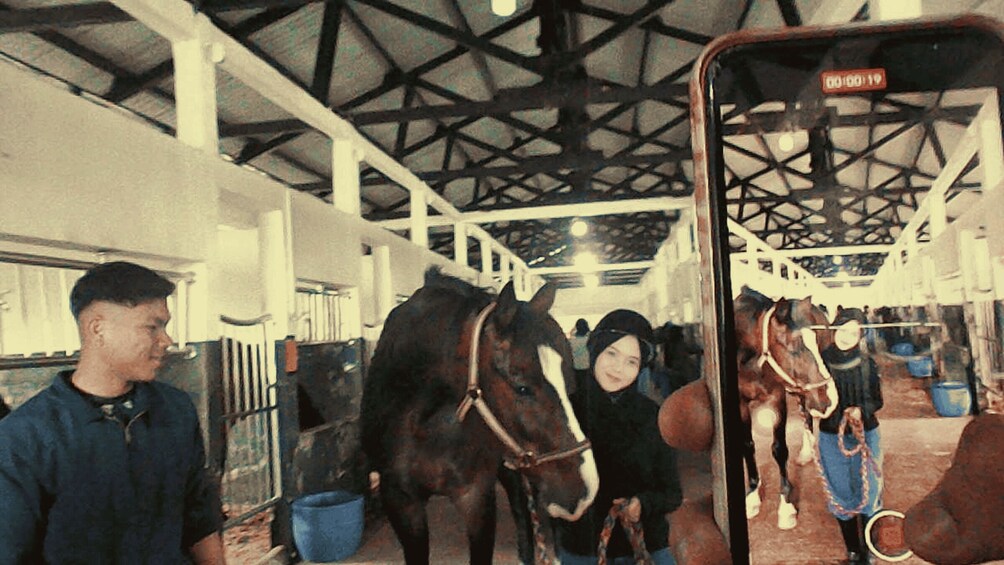 A stable with horses and people. 5