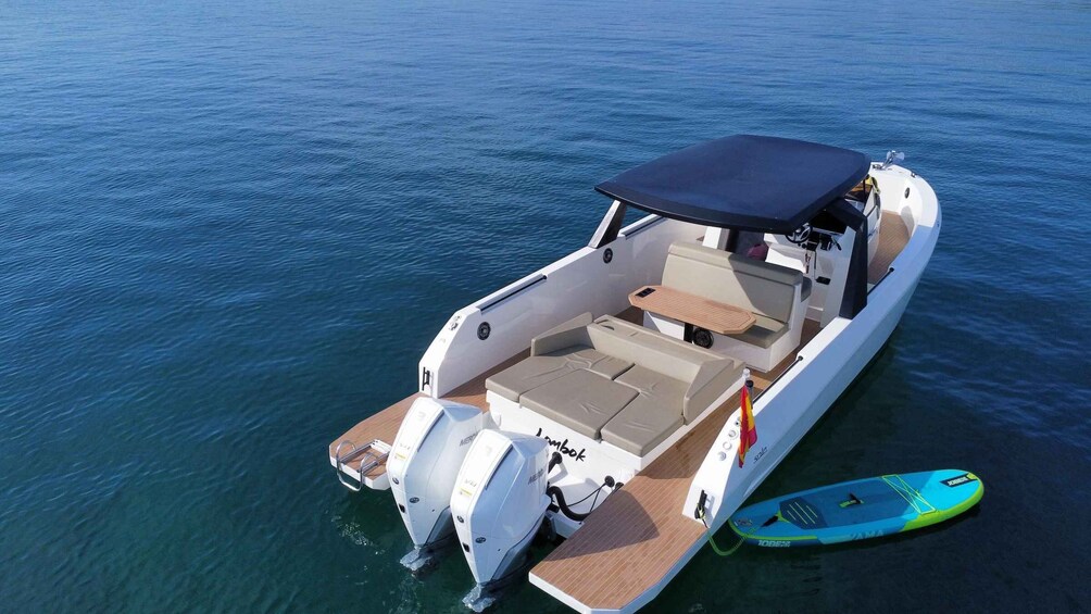 A motorboat with a canopy, seating, and a wakeboard. 3