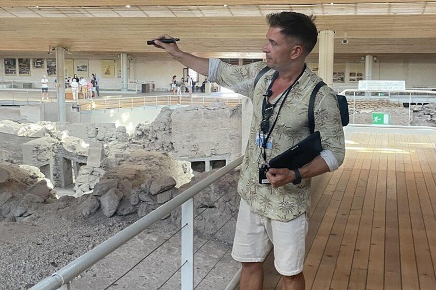Une personne qui désigne un site archéologique avec des ruines et un plancher en bois. 1