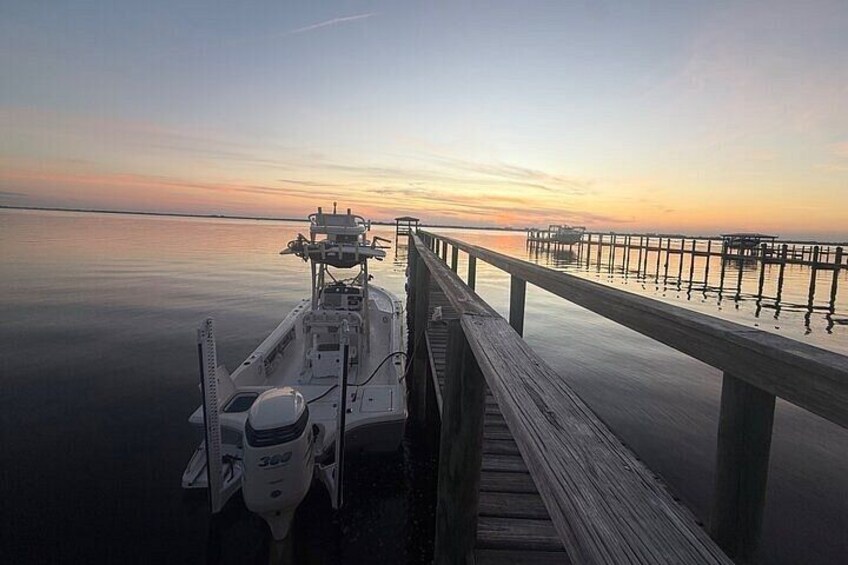 A boat docked at a pier during sunset. 2