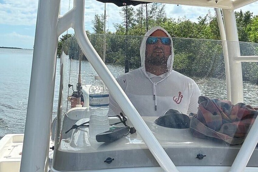Une personne à bord d’un bateau, avec une bouteille d’eau et du matériel de pêche. 3