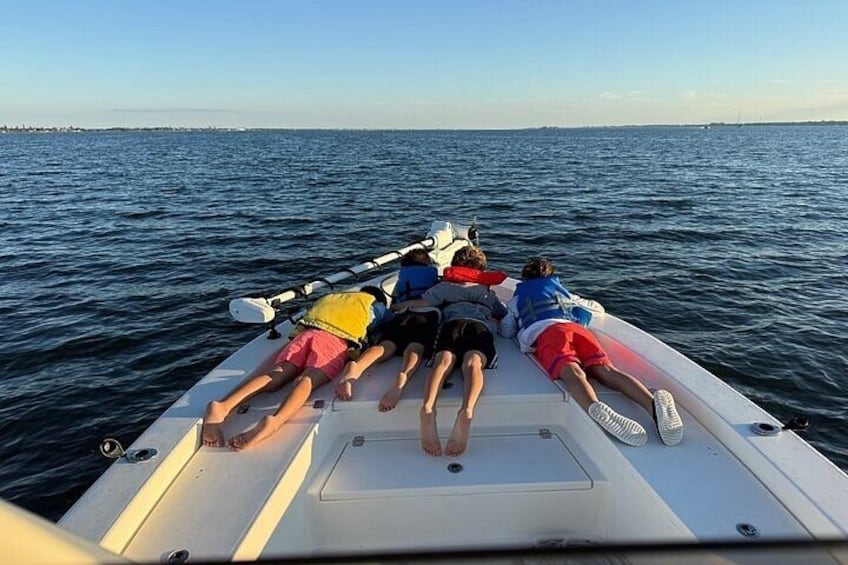 Een groep mensen ligt op een boot op het water. 4