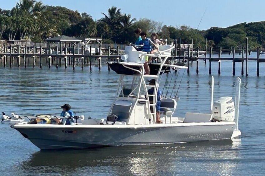 Een boot aan een steiger met mensen aan boord en een pier die het water in reikt. 3