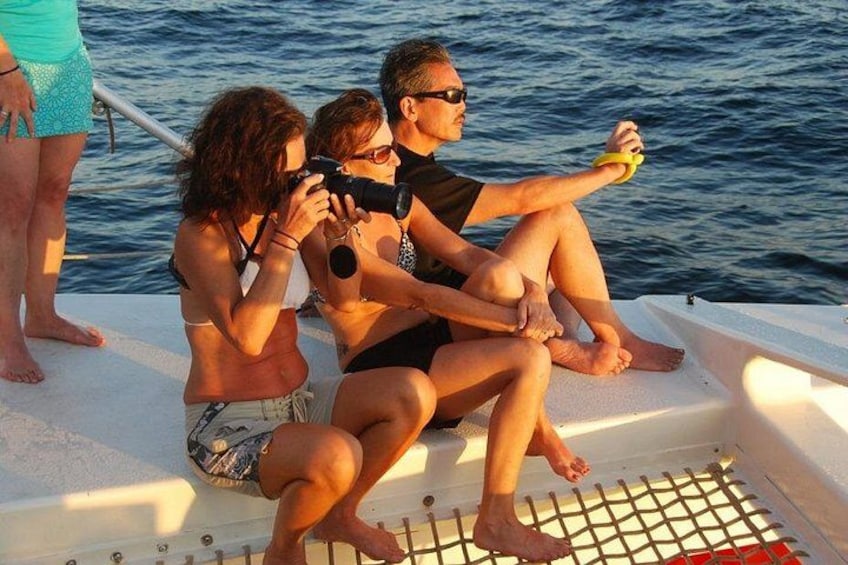 Drie mensen in een bootje, waarvan er één een foto maakt, een ander een camera vasthoudt, en een derde zit. 5