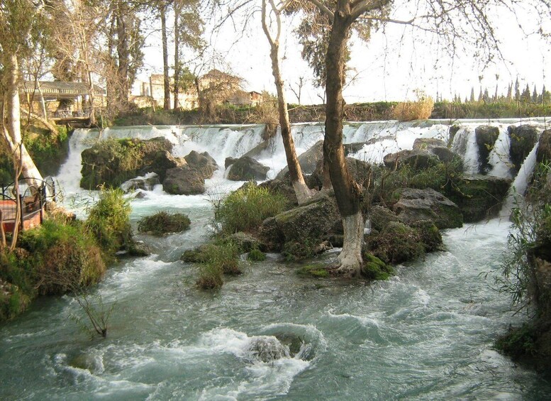 A river with multiple waterfalls, surrounded by trees and rocky terrain. 4