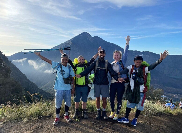 A group of hikers on a mountain trail with a clear sky and a mountain in the background. 4
