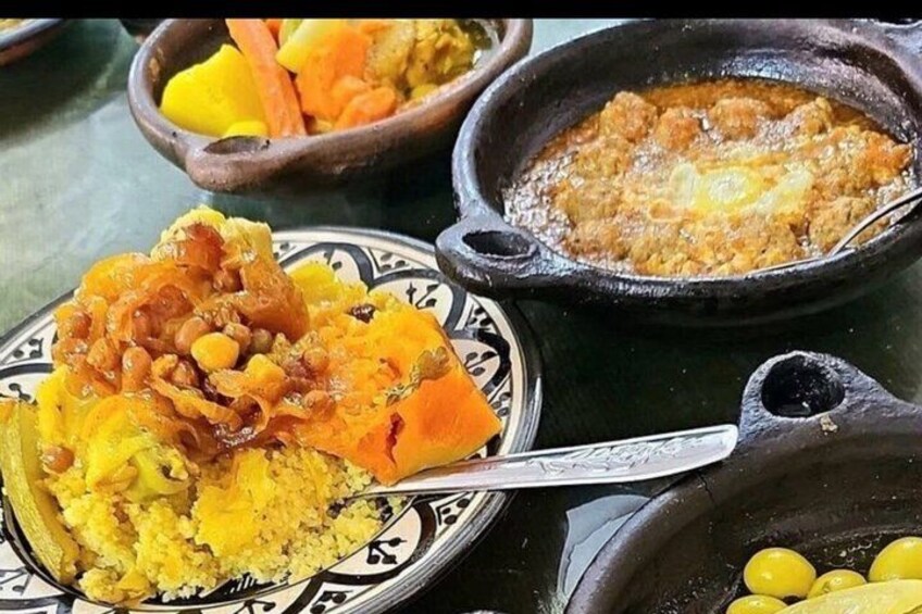 A variety of dishes including a bowl of couscous, a pot of stew, and a plate with a piece of meat and vegetables. 4