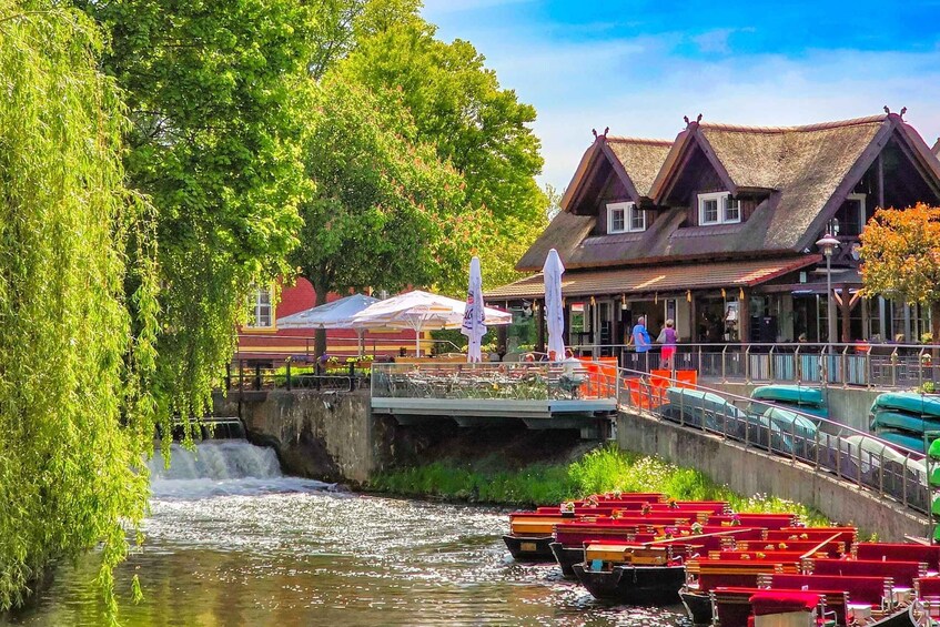 A river with boats, a bridge, and buildings with thatched roofs. 2