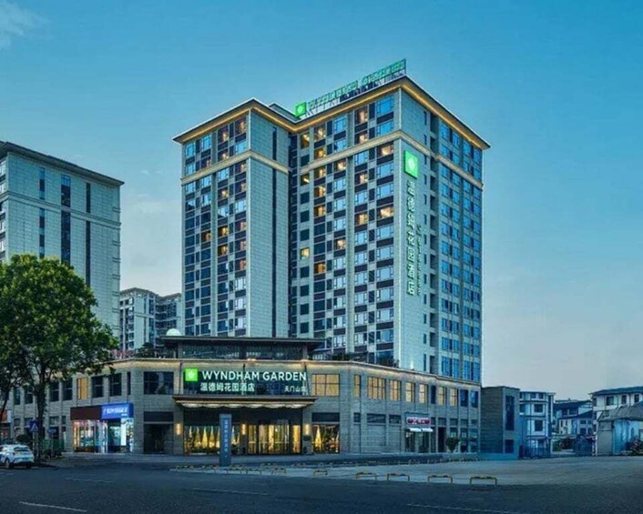 A multi-story building with a green sign for WYNDHAM GARDEN. 2