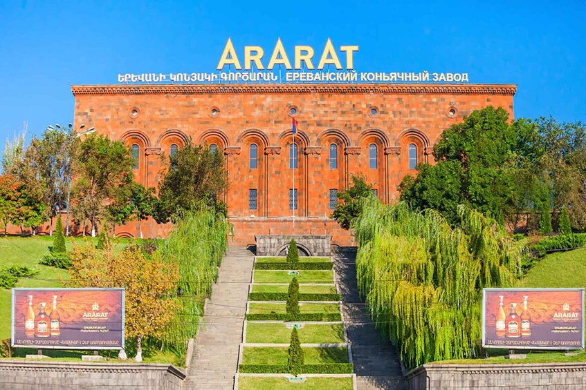 A large red brick building with the name 'ARARAT' on the facade. There are two large banners on either side of the entrance. 3