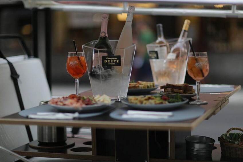 Een tafel met eten, drinken en een fles champagne. 5