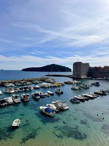 A harbor with numerous boats docked, a castle-like structure, and a clear blue sky. 3