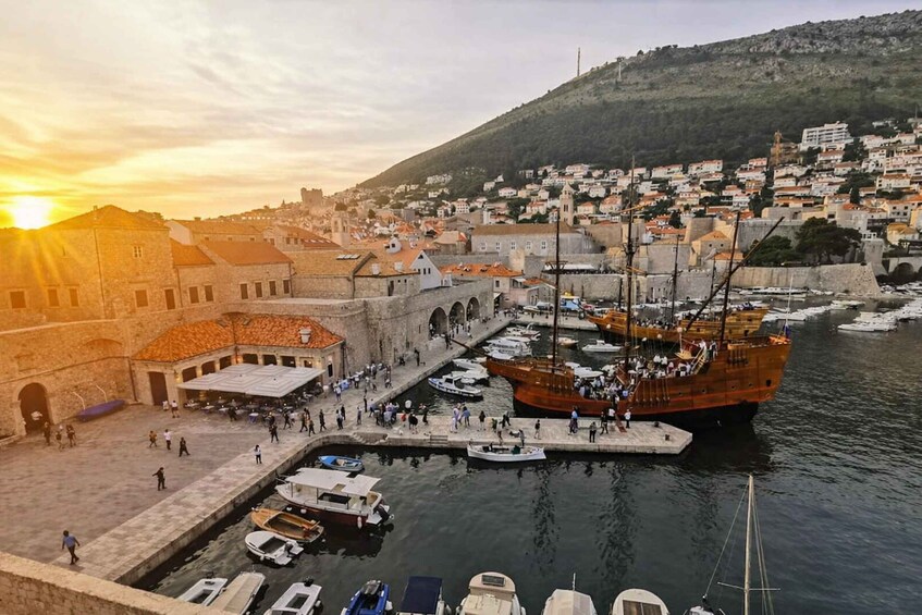 A harbor with boats, a large ship, and historic buildings. 1