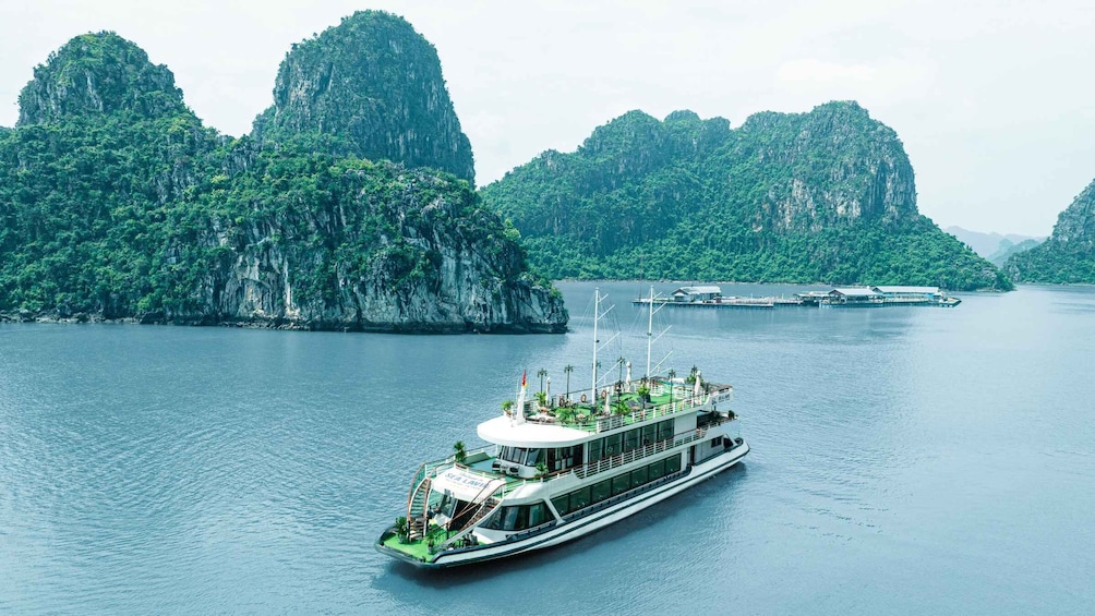 A river cruise boat with a white deck and green surroundings, surrounded by lush green cliffs. 4