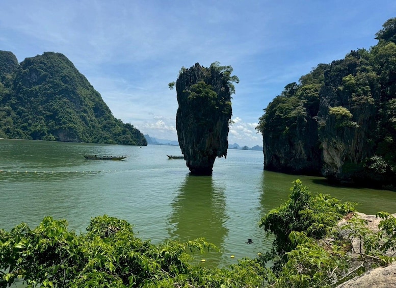 A river with boats, surrounded by lush green cliffs. 1