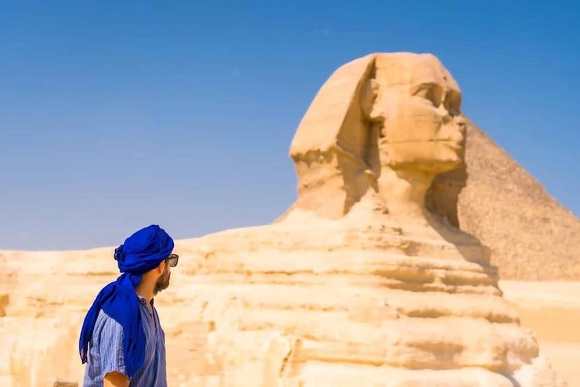 A person standing in front of the Great Sphinx of Giza. 4