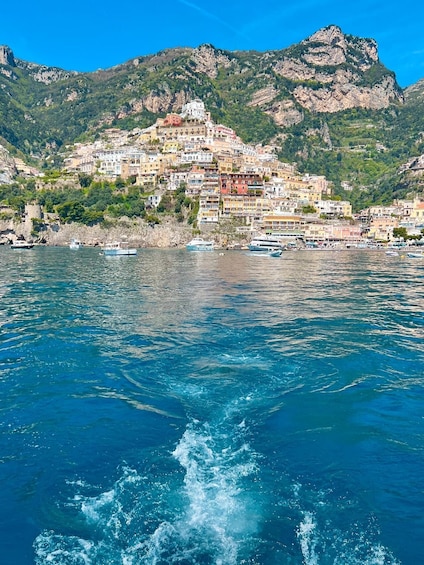 A coastal town with colorful buildings, boats on the water, and mountains in the background. 4