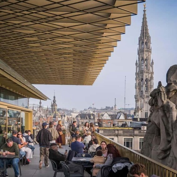A rooftop café with people dining and a historic cathedral in the background. 3
