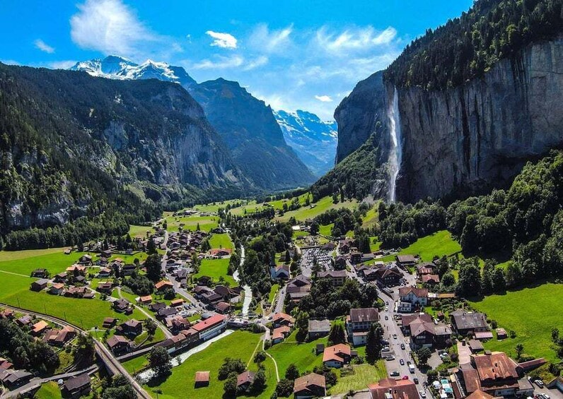 A village nestled between mountains with a waterfall. 5