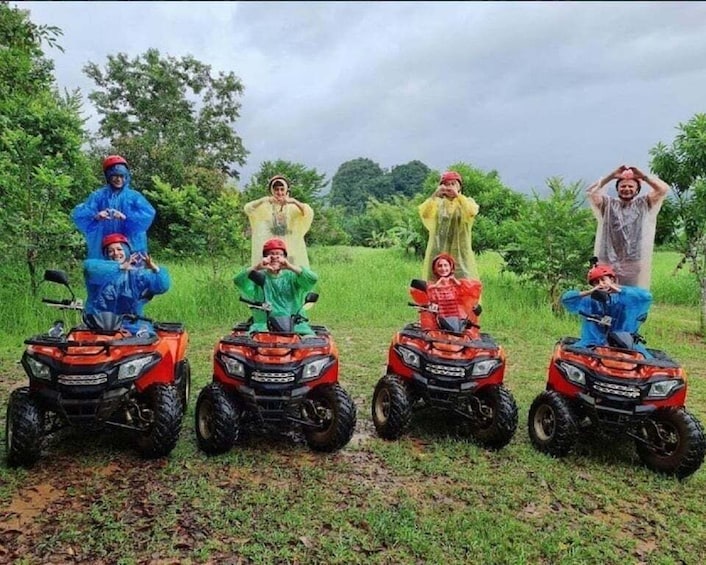 Four people on all-terrain vehicles in a grassy field. 4
