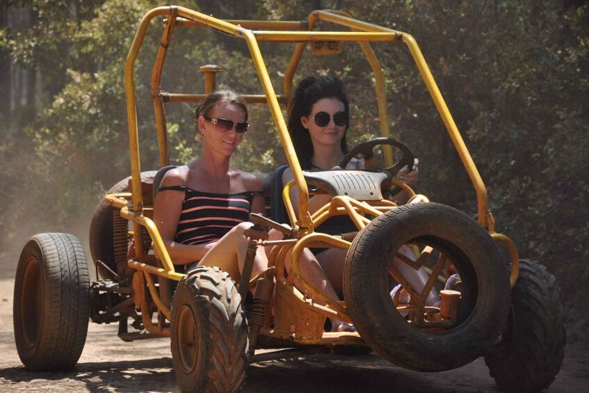 A yellow off-road vehicle with large tires on a dirt path. 3