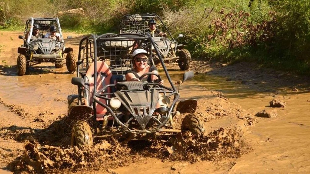 Off-road vehicles navigating a muddy terrain with water crossings. 4