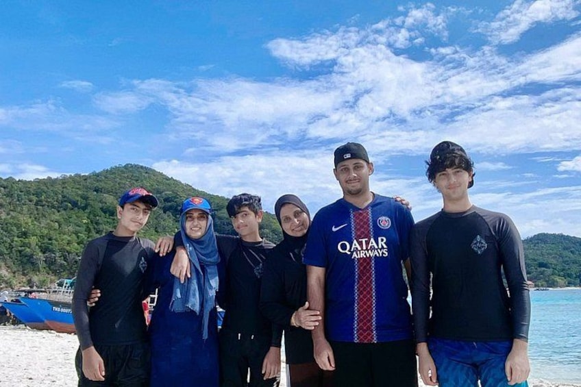 A group of people on a beach with a mountainous background. 5