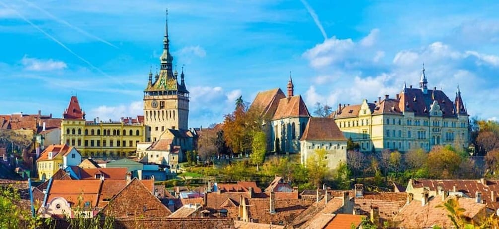 A historic town with a prominent tower, a church, and a large manor house. 1