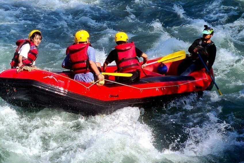 A group of people in a red inflatable raft on a river. 5